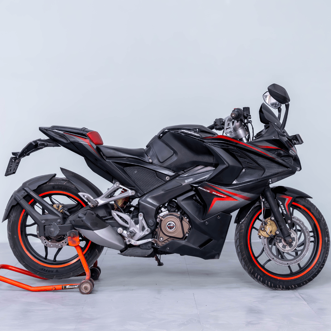 Bajaj Pulsar RS 200 black sports bike with red accents, right-side profile on a paddock stand.