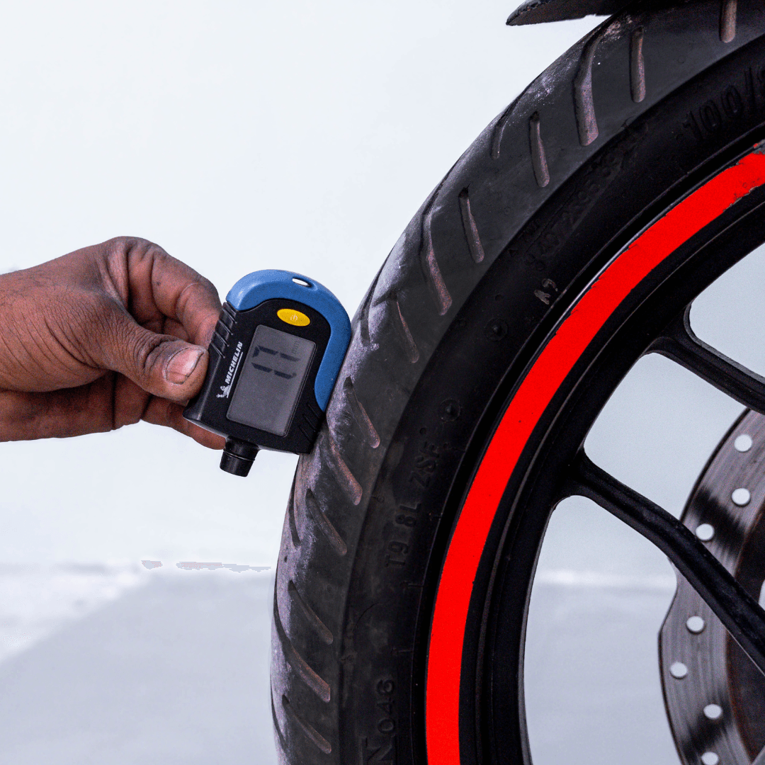 Tire tread depth measurement on Bajaj Pulsar RS 200 front wheel using a digital gauge.