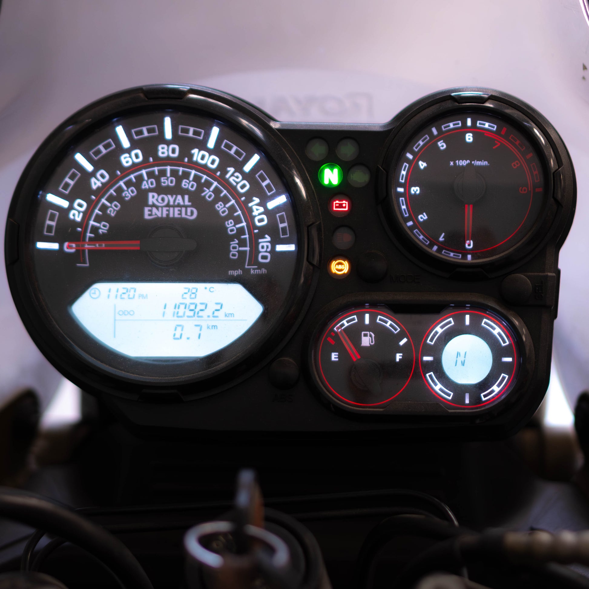 Close-up of a motorcycle dashboard with various gauges and indicators.
