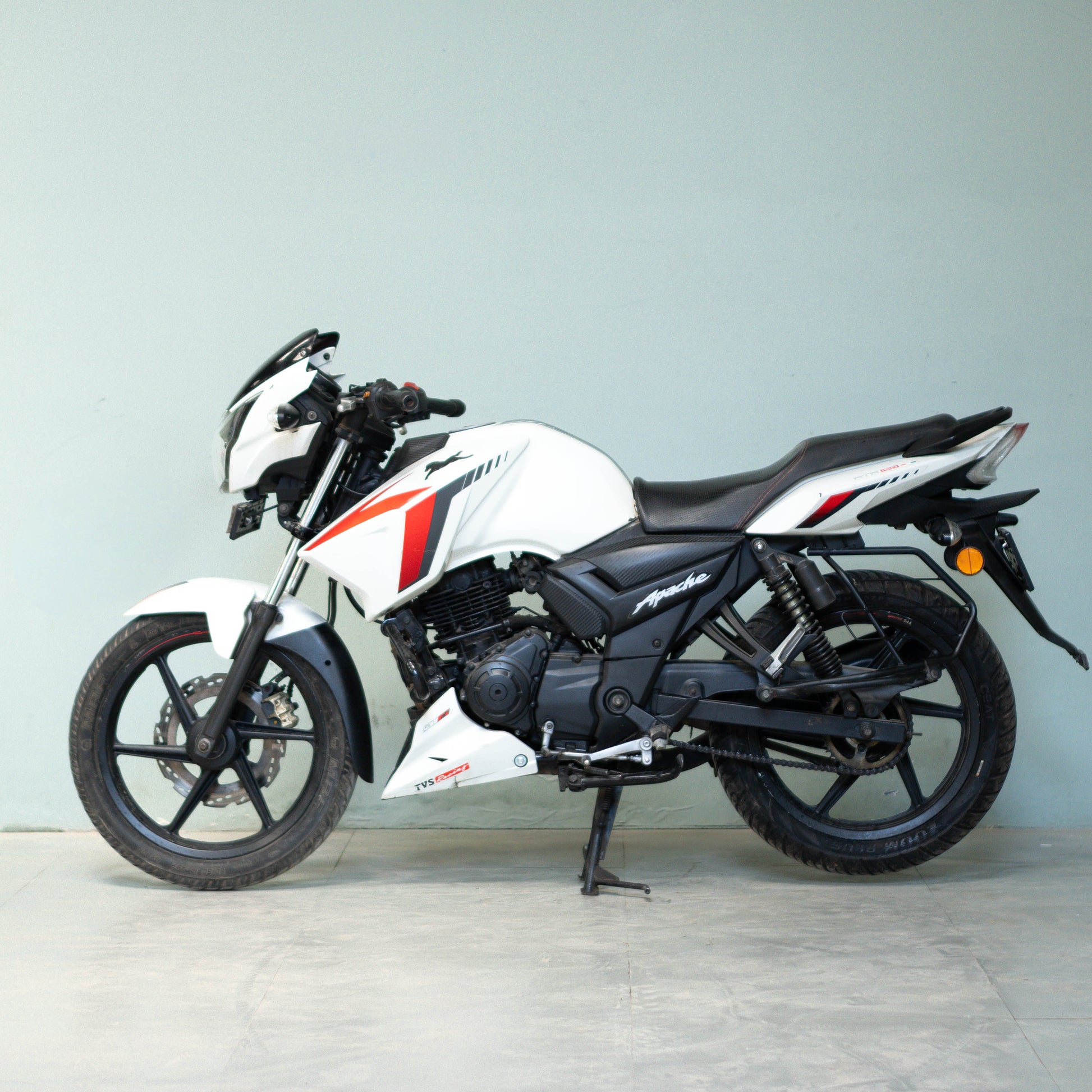 White motorcycle with black and red accents on a light gray background used-tvs-apache-rtr-160-4v-gurgaon