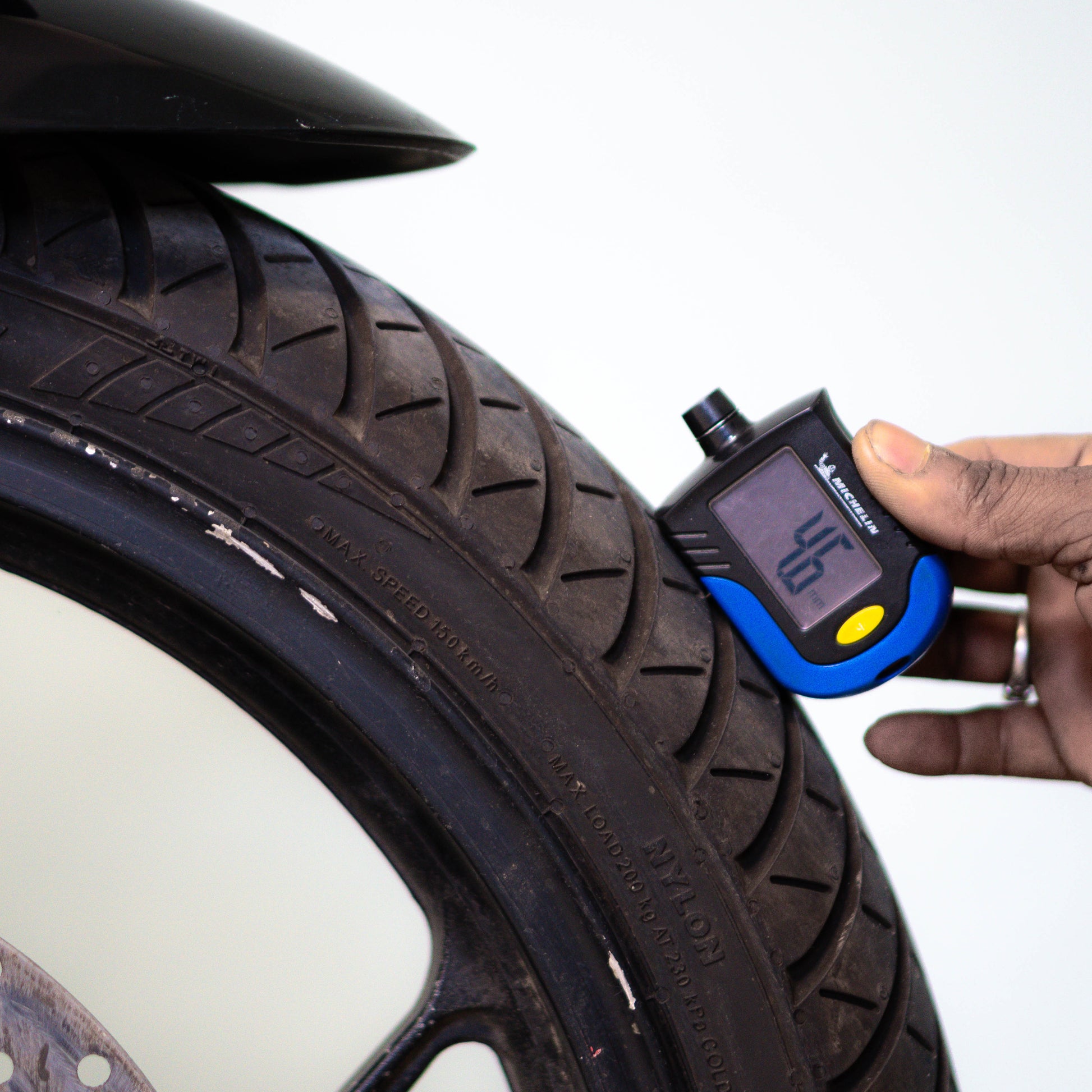 Tire pressure gauge being used on a car tire with a white background Suzuki Gixxer SF 150 Used Bike for Sale in Gurgaon