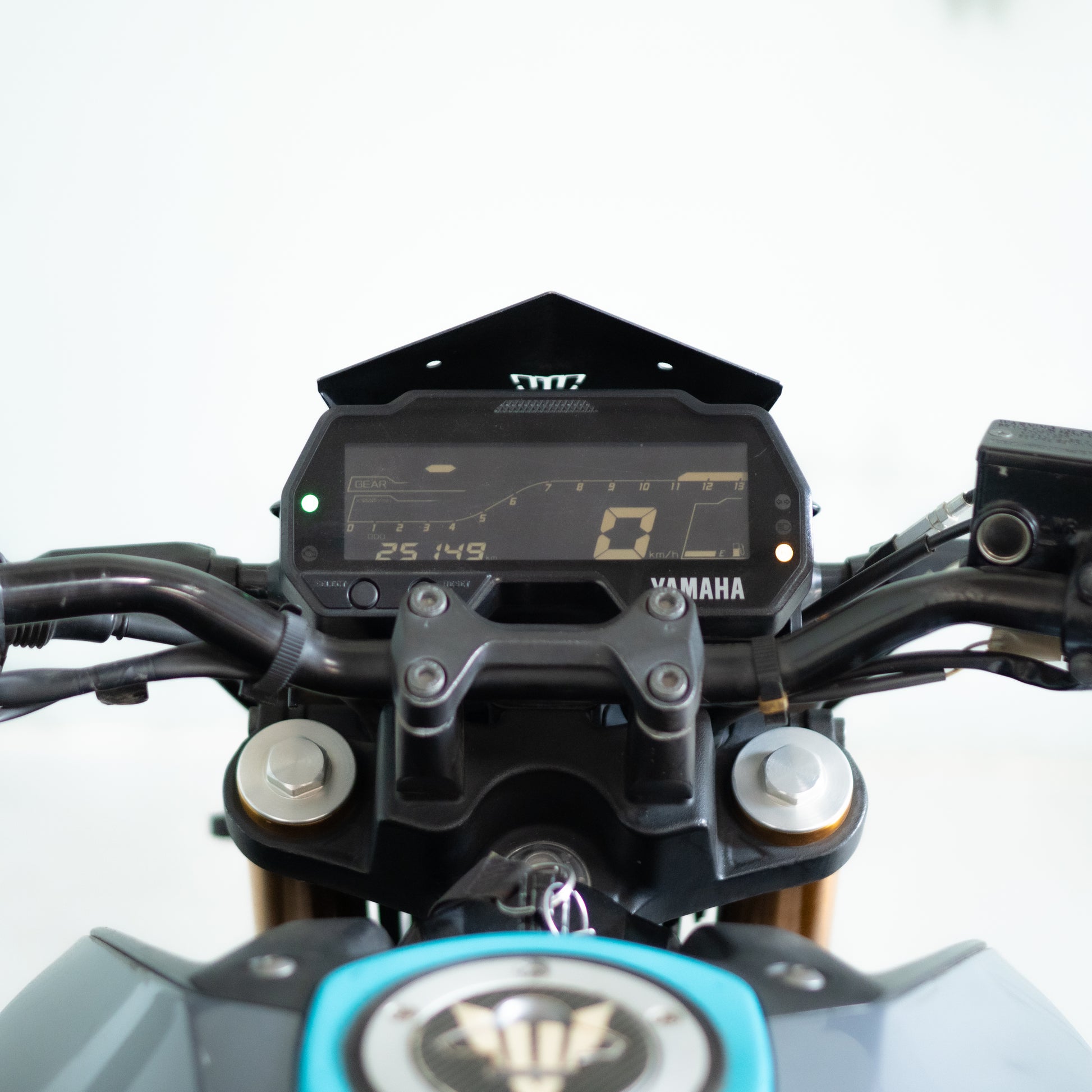 Close-up of a Yamaha motorcycle dashboard with digital display on a white background